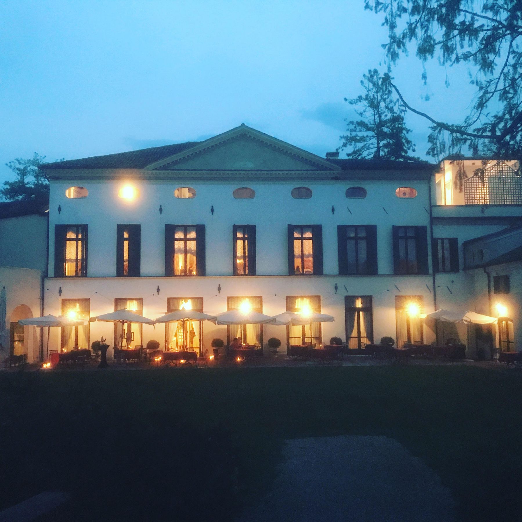 Italian villa at dusk – Palladian architecture, terrace with candle-lit parasols, destination wedding venue