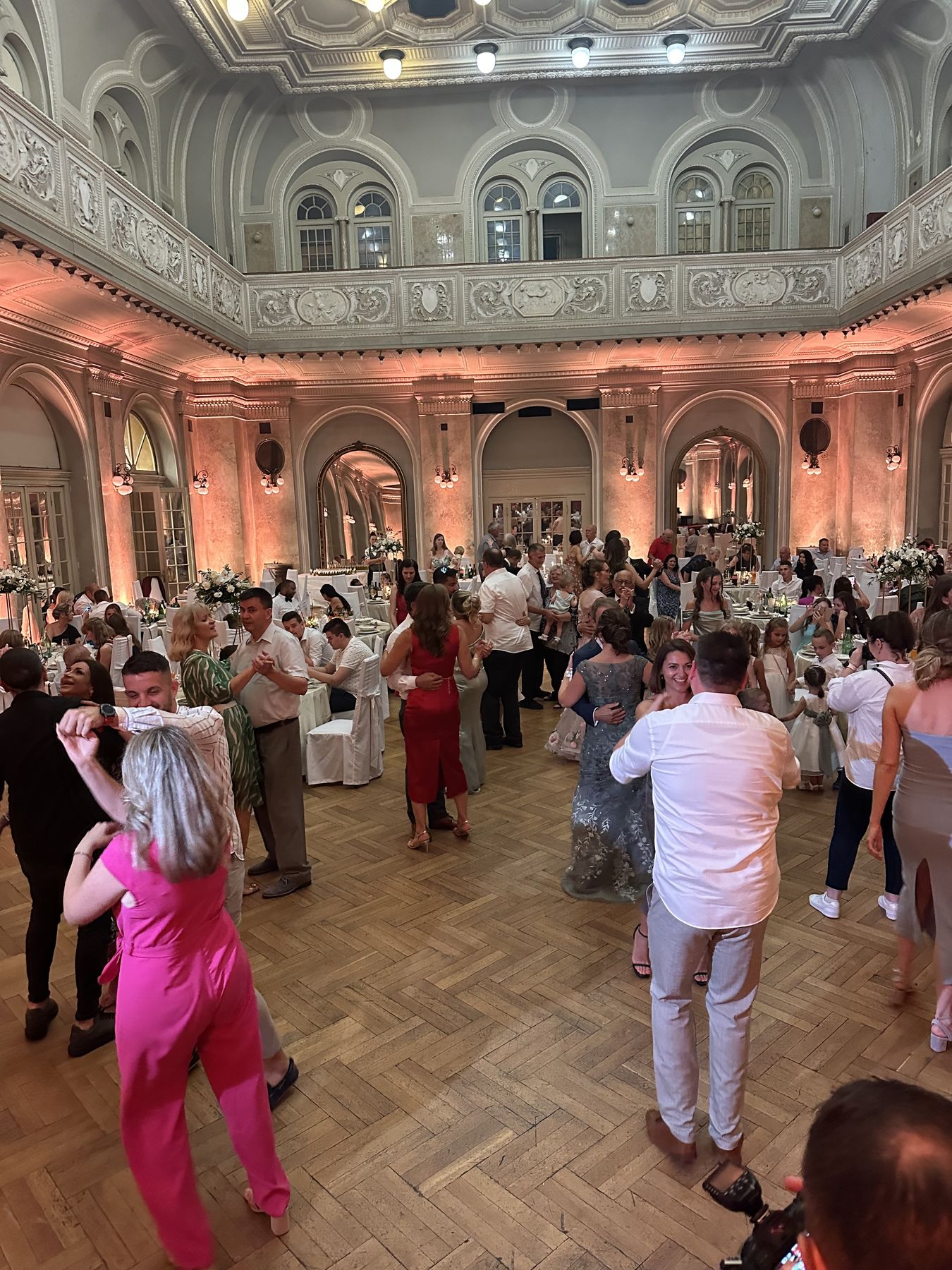 Party set u istarskoj balskoj dvorani – ornamentirana arhitektura, peach uplighting, gosti plešu