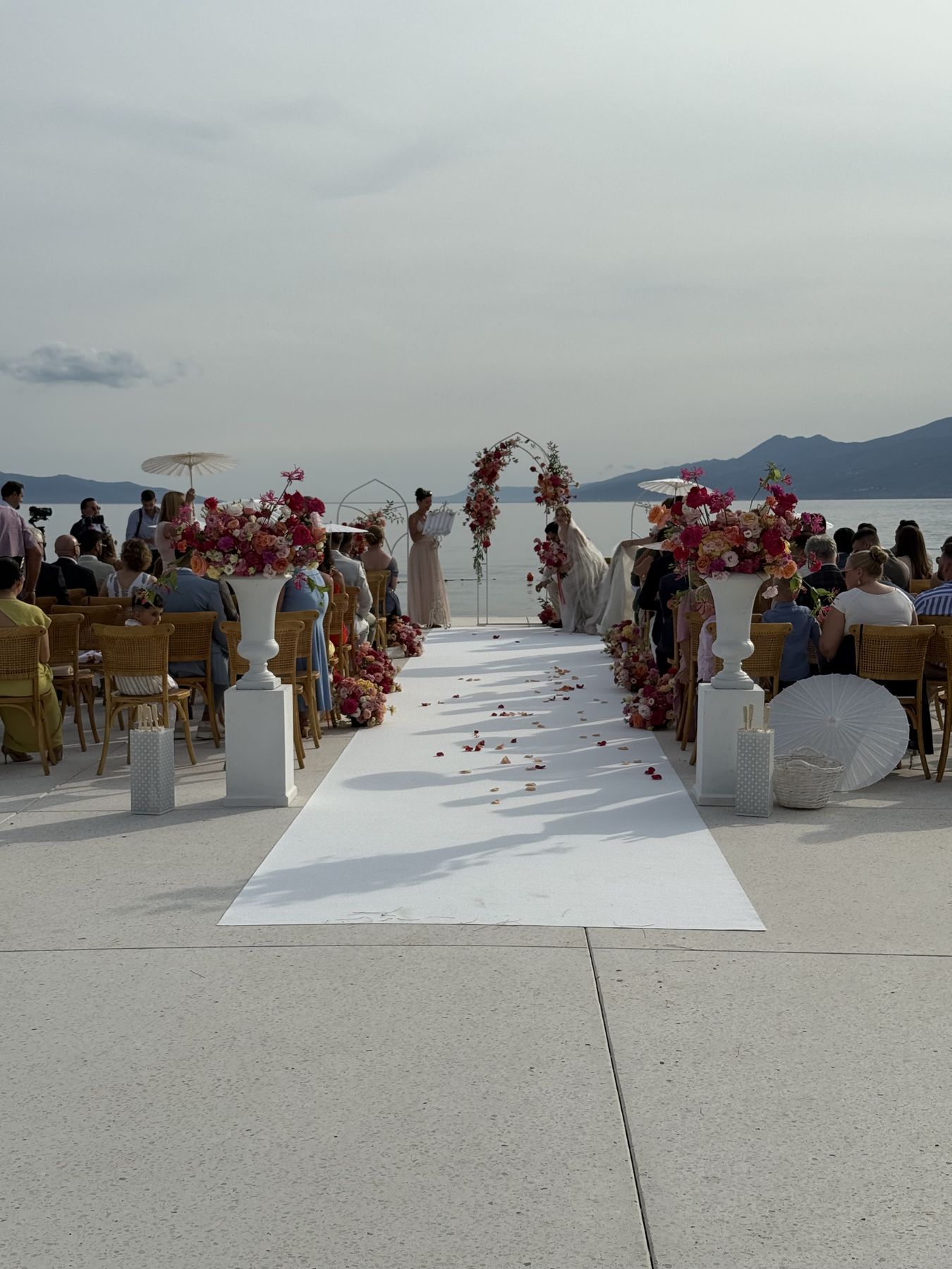 Vjenčana ceremonija na obali Kvarnera – mladenci pod cvjetnim lukom, more, planine u pozadini